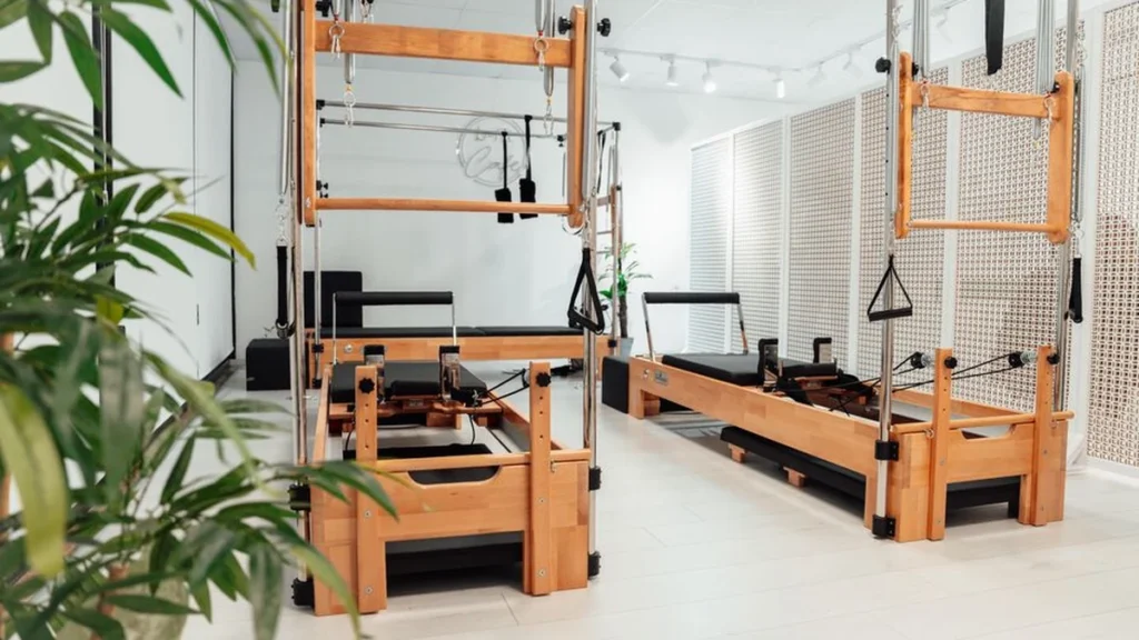 Mat Pilates classes: a woman on a padded mat in a calm neutral studio